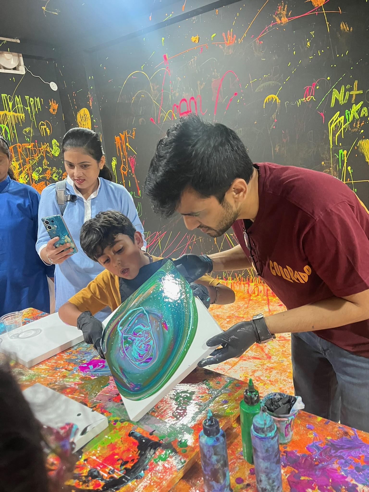 Acrylic paint being poured onto a canvas at Splashit